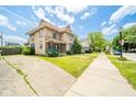 A charming two-story home is showcased from the sidewalk, displaying its well-kept lawn and neighborhood charm at 917 W 8Th St, Anderson, IN 46016