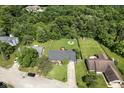 This home features a large, fenced backyard with a small wooden deck and mature trees surrounding the property at 9265 Brunson Run, Indianapolis, IN 46256