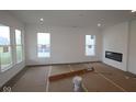 Bright living room with large windows, modern fireplace, and neutral walls ready for personalization at 10604 Maidenhair Dr, Indianapolis, IN 46239