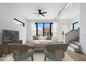 Bright living room featuring modern decor, a ceiling fan, and large windows offering neighborhood views at 1100 English Ave, Indianapolis, IN 46203