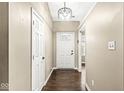A welcoming foyer with hardwood floors, a white front door and classic lighting fixture at 1540 Brook Pointe Dr, Indianapolis, IN 46234