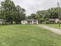 Expansive front lawn leads up to this charming single-story home with neutral siding at 1603 S Morgantown Rd, Greenwood, IN 46143