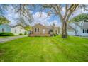 Inviting single-story home with a stone facade, neat lawn, and mature trees providing ample shade at 171 Nursery Rd, Anderson, IN 46012