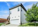 Modern two-story home featuring a front-facing garage, stylish siding, and a landscaped lawn at 2008 Yandes St, Indianapolis, IN 46202