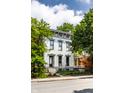 Beautifully renovated two-story white house featuring an ornamental fence, porch and manicured yard at 214 E St Joseph St, Indianapolis, IN 46202