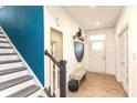 Bright entryway with stylish bench, painted accent wall and staircase at 265 Gathering Ln, Greenwood, IN 46143
