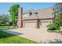 Exterior view of a brick home showing a three car garage and a basketball hoop in the driveway at 2901 Hazel Foster Dr, Carmel, IN 46033