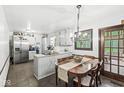 Cozy kitchen with white cabinets, stainless steel appliances, and a dining area with a chandelier at 3090 N County Road 800 E Rd, Brownsburg, IN 46112