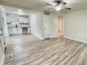 Open-concept living space with new flooring and contemporary ceiling fan, adjoined to the kitchen area at 3712 S Kealing S Ave, Indianapolis, IN 46237