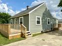 A charming exterior showcasing tidy siding, a front deck, and well-manicured landscaping at 405 E Cowing Dr, Muncie, IN 47303