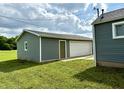 Detached garage featuring tidy siding and a large bay door at 405 E Cowing Dr, Muncie, IN 47303
