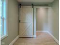 Hallway view featuring a sliding barn door adding rustic charm and visual interest to the space at 4903 E Naomi St, Indianapolis, IN 46203