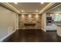 Spacious living area with a stone accent wall, modern lighting, and sleek hardwood floors at 4903 E Naomi St, Indianapolis, IN 46203