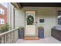 Charming front door with wreath, welcome mat, and potted flower decoration at 519 Sutherland Ave, Indianapolis, IN 46205