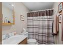 Modest bathroom with a toilet, vanity sink and a shower with a striped and patterned curtain at 618 Shady Creek Dr, Greenwood, IN 46142