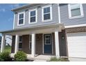 Inviting front entrance with brick accents, white columns, and a dark blue front door with glass features at 6218 N Woodside Ct, McCordsville, IN 46055