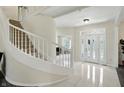 Grand foyer with white staircase, a striking front door, and marble floors at 6316 Harmonridge Ct, Indianapolis, IN 46278