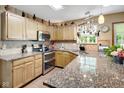 Well-lit kitchen with granite countertops, stainless steel appliances, and tile backsplash at 6439 Bower Dr, Indianapolis, IN 46241