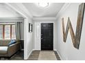 Inviting entryway with a black front door, neutral walls, decorative accents, and luxury vinyl plank flooring at 8030 5 Points Rd, Indianapolis, IN 46259