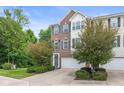 Townhome exterior features well-maintained brick and siding, an attached garage, and lush landscaping at 9046 Sparta Dr, Fishers, IN 46038