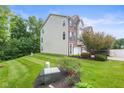 This townhome features well-maintained landscaping, a private driveway, and a blend of brick and siding on the exterior at 9046 Sparta Dr, Fishers, IN 46038