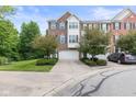 A charming townhome with brick and siding, a well-kept lawn, and a private driveway leading to an attached garage at 9046 Sparta Dr, Fishers, IN 46038