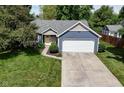 Beautiful home featuring a two-car garage, yellow door and a lush lawn with mature trees at 9170 Andiron Way, Indianapolis, IN 46250