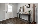 Bright foyer with wood floors, a decorative table, mirror, and a coat rack near the front door at 9407 Casey Rd, Pendleton, IN 46064
