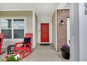 Inviting front porch with red rocking chairs and a bright red front door, offering a warm welcome at 9858 Bryce Blvd, Pendleton, IN 46064