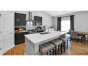 Modern kitchen boasts an island with bar stool seating, stainless steel appliances, and sleek, dark cabinetry at 9858 Bryce Blvd, Pendleton, IN 46064