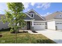 Charming home featuring stone accents, gray siding, and a convenient two-car garage at 10602 Maidenhair Dr, Indianapolis, IN 46239