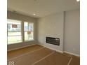 Bright living room featuring large windows and a modern electric fireplace at 10602 Maidenhair Dr, Indianapolis, IN 46239
