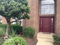 Elegant front entrance with a burgundy door, a large transom window and meticulous landscaping at 1273 Helford Ln, Carmel, IN 46032