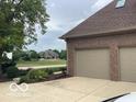 Attached two car garage with a paved driveway and landscaping at 1273 Helford Ln, Carmel, IN 46032