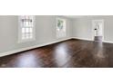 Inviting living room with hardwood floors, gray walls, white trim, and windows that bring in natural lighting at 1418 W 5Th St, Anderson, IN 46016