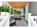 Inviting front porch with a cozy seating area, stylish rug, and a warm, wood-paneled ceiling at 1504 Manhattan Ave, Indianapolis, IN 46241