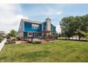 A well-manicured lawn with a wooden deck, pergola, a blue-sided two-story home and privacy fence at 1521 Midnight Pass, Brownsburg, IN 46112