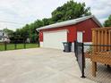 Spacious red outbuilding featuring a large roll-up door, perfect for workshop at 160 E Elm St, Morgantown, IN 46160