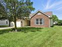 Beautiful home featuring brick accents, a lush lawn, and mature trees at 1702 Juniper Ln, Greenwood, IN 46143