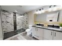 Modern bathroom featuring a double sink vanity and a walk-in shower with mosaic tile at 1809 S H St, Elwood, IN 46036