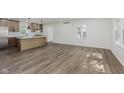 Open-concept living space with stylish flooring and a bright, updated kitchen in the background at 20797 Roberts Dr, Sheridan, IN 46069