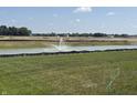 Scenic view of a pond with a fountain, surrounded by green grass and trees in a peaceful community setting at 2954 Grand Rdg Dr, Greenwood, IN 46143