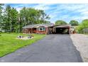 Charming single-story home with a covered parking area and a well-maintained lawn at 3038 S Richardt Ave, Indianapolis, IN 46239