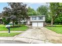 Charming two-story home featuring tidy landscaping, a two-car garage, and blue shutters at 317 Heritage Ct, Fishers, IN 46038