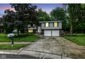 Charming two-story home with a two-car garage, gray siding, brick facade, and well manicured lawn at 317 Heritage Ct, Fishers, IN 46038