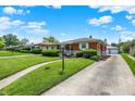 Well-maintained ranch-style home with a green lawn, long driveway, and charming curb appeal in a tranquil neighborhood at 3322 N Riley N Ave, Indianapolis, IN 46218