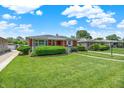 Classic ranch-style home with lush green lawn, mature shrubbery, and inviting curb appeal on a sunny day at 3322 N Riley N Ave, Indianapolis, IN 46218