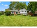 Charming split-level home featuring a brick facade, a two-car garage, and lush landscaping at 3388 S Leonard Rd, New Palestine, IN 46163