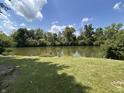 Scenic view of the community pond, framed by lush greenery and a clear blue sky with fluffy clouds at 3525 Valley Lake Dr, Indianapolis, IN 46227