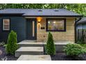 Inviting home featuring a modern black door, stylish exterior lighting, and light wood accents at 4245 Norwaldo Ave, Indianapolis, IN 46205